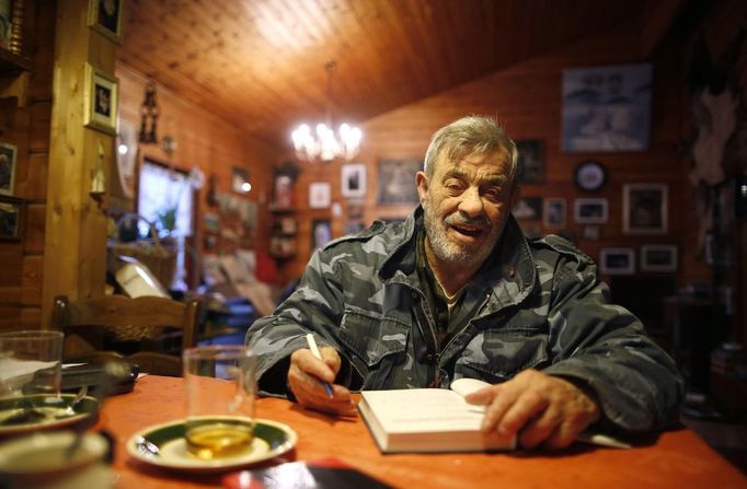 Wolf researcher Werner Freund sits at a table in his home near Wolfspark Werner Freund, in Merzig in the German province of Saarland January 24, 2013. Freund, 79, a former German paratrooper, established the wolf sanctuary in 1972 and has raised more than 70 animals over the last 40 years. The wolves, acquired as cubs from zoos or animal parks, were mostly hand-reared. Spread over 25 acres, Wolfspark is currently home to 29 wolves forming six packs from European, Siberian, Canadian, Artic and Mongolian regions. Werner has to behave as the wolf alpha male of the pack to earn the other wolves respect and to be accepted. Picture taken January 24, 2013. REUTERS/Lisi Niesner (GERMANY - Tags: ANIMALS SOCIETY) Published: Led. 26, 2013, 2:45 odp.