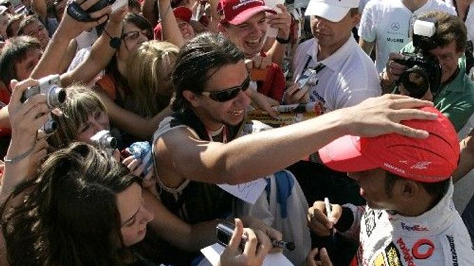 Pilot stáje McLaren Lewis Hamilton rozdává autogramy v dějišti víkendové velké ceny v maďarské Budapešti.