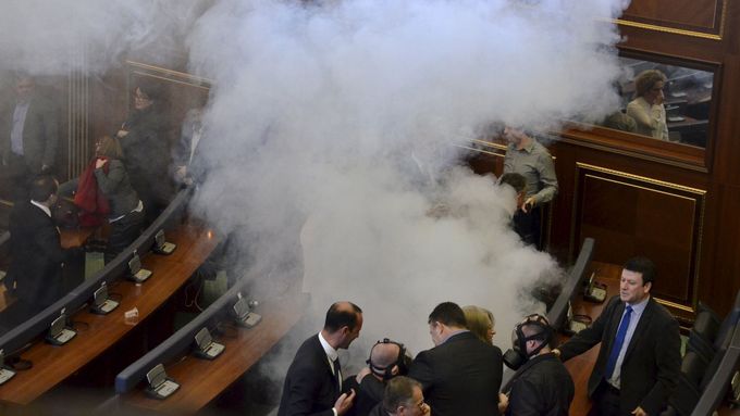 Tak vypadají obstrukce v kosovském parlamentu. Opoziční poslanci v plynových maskách vypouštějí z lavic slzný plyn.