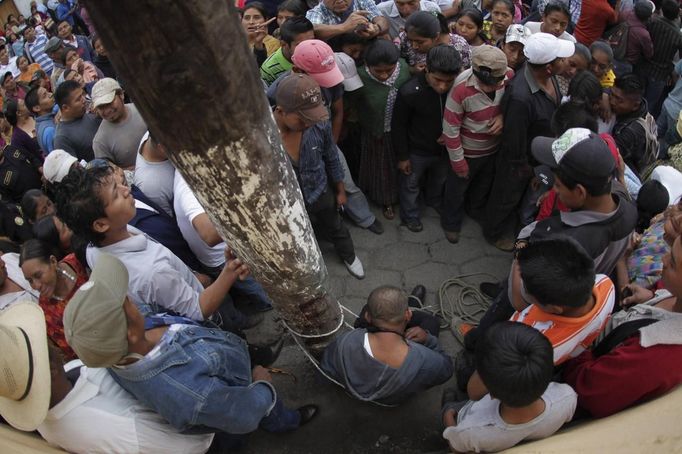 A man is tied up and beaten by the villagers of Tactic, in Alta Verapaz region, some 189km (117 miles) from Guatemala City, September 13, 2012. The local community tied up and beat four men who were accused of theft in the aftermath of a school killing, which had occurred on Wednesday. The man, who had entered a classroom and killed two children, ages 8 and 13, with a machete, was lynched and burnt alive by a mob, local media reported. REUTERS/Jorge Dan Lopez (GUATEMALA - Tags: CRIME LAW SOCIETY) Published: Zář. 13, 2012, 6:27 odp.