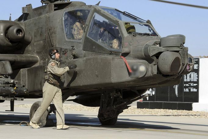 Britain's Prince Harry (R partially obscured) sits in the cockpit of an Apache helicopter in Camp Bastion, southern Afghanistan in this photograph taken November 1, 2012, and released January 21, 2013. The Prince, who is serving as a pilot/gunner with 662 Squadron Army Air Corps, is on a posting to Afghanistan that runs from September 2012 to January 2013. Photograph taken November 1, 2012. Photograph pixelated at source. REUTERS/John Stillwell/Pool (AFGHANISTAN - Tags: MILITARY POLITICS SOCIETY ROYALS CONFLICT) Published: Led. 21, 2013, 8:06 odp.