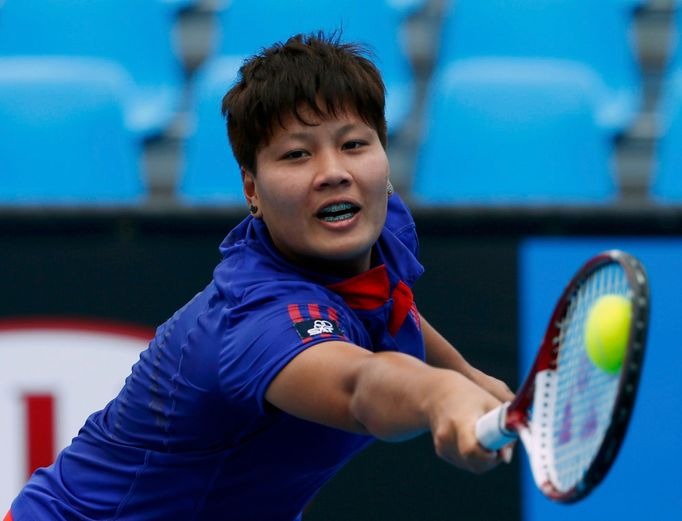 Luksika Kumkhum of Thailand hits a return to Mona Barthel of Germany during their women's singles match at the Australian Open 2014 tennis tournament in Melbourne January