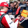 Ferrari Formula One driver Kimi Raikkonen of Finland signs autographs as he arrives for the first practice session of the Australian F1 Grand Prix at the Albert Park circuit in Melbourne