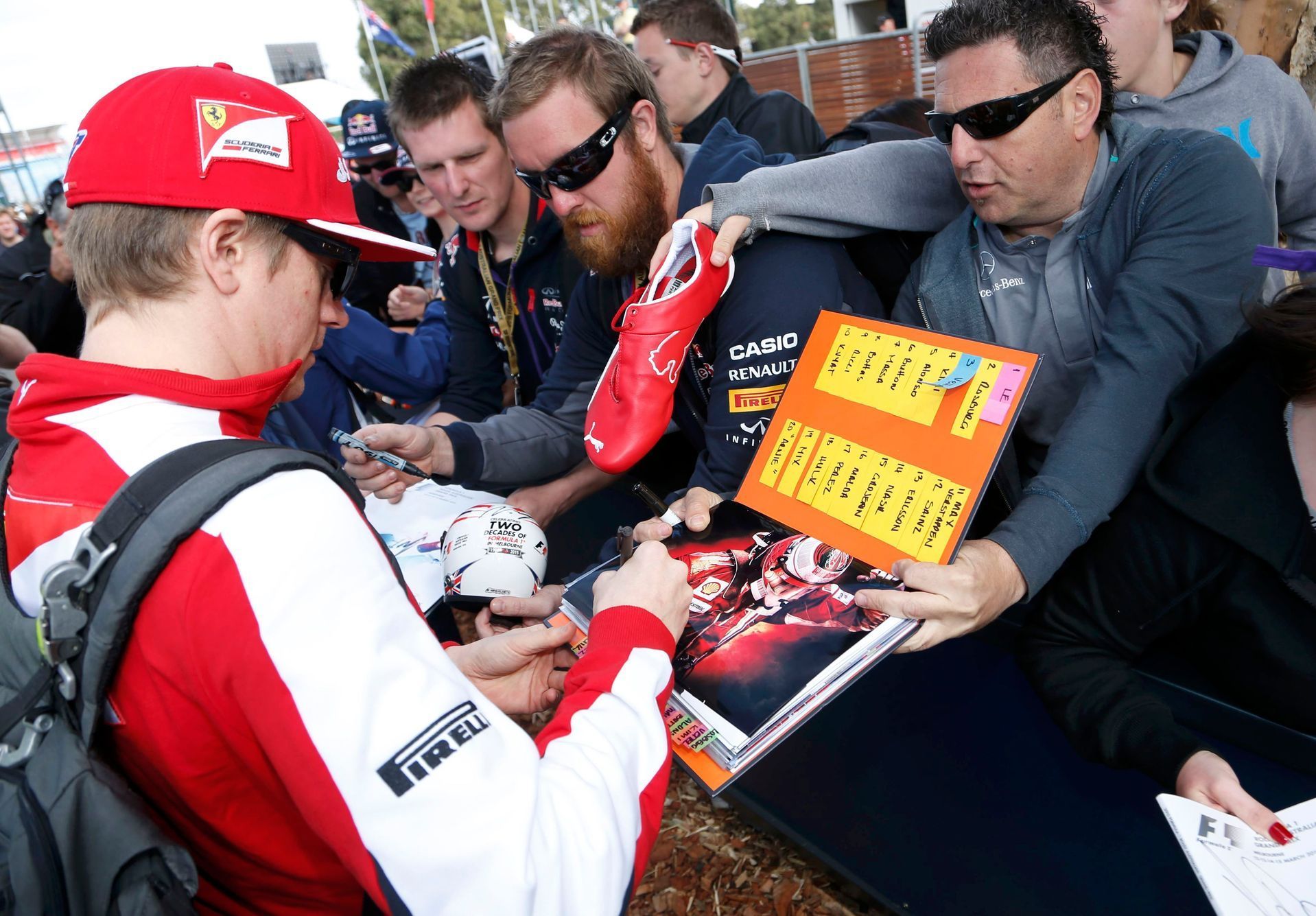 Ferrari Formula One driver Kimi Raikkonen of Finland signs autographs as he arrives for the first practice session of the Australian F1 Grand Prix at the Albert Park circuit in Melbourne