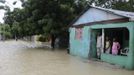 A family looks out from their porch at the floodwater from Tropical Storm Isaac in Vicente Noble, Barahona province, August 25, 2012. Tropical Storm Isaac emerged over warm Caribbean waters on Saturday slightly weaker but ready to regroup after dumping torrential rains on the Dominican Republic and Haiti. REUTERS/Ricardo Rojas (DOMINICAN REPUBLIC - Tags: DISASTER ENVIRONMENT) Published: Srp. 25, 2012, 5 odp.