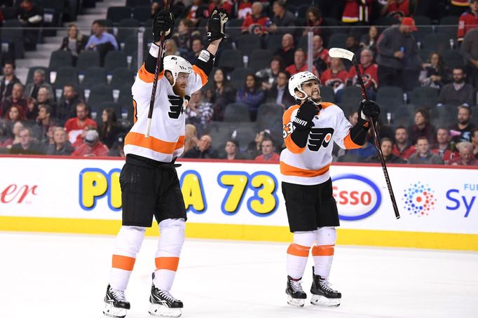 Jakub Voráček (vlevo) a Shayne Gotisbehere slaví vítězství Philadelphie na ledě Calgary