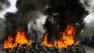 Miners on strike stand behind barricades of buring tires on the A-66 motorway, on the first day of a strike to protest the government's spending cuts in the mining sector, in Pola de Lena, near Oviedo, northern Spain, May 23, 2012. Spain's economy is contracting for the second time since late 2009 and four years of stagnation and recession have pushed unemployment above 24 percent, the highest rate in the European Union. REUTERS/Eloy Alonso (SPAIN - Tags: CIVIL UNREST ENERGY BUSINESS COMMODITIES POLITICS) Published: Kvě. 23, 2012, 11:09 dop.