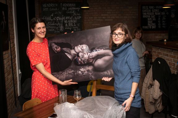 Fotografka Martina Houdek (vpravo) předává snímek určený pro dobročinnou dražbu psycholožce Kristýně Maulenové z organizace Amélie.