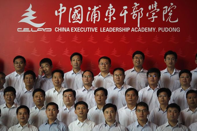 Trainees pose for a group photo after finishing a training course at the communist party school called China Executive Leadership Academy of Pudong in Shanghai, September 24, 2012. China's Communist Party has dramatically stepped up its training of the country's roughly 40 million party and government officials in the past decade. With public scrutiny of cadre behaviour growing via social media, the party is likely to call for continued, and deepened, cadre education at the upcoming 18th Party Congress. At the vanguard of this education drive, alongside a Central Party School in Beijing, are three "Executive Leadership Academies" which opened in 2005 for middle-ranking and senior officials in Shanghai, Yan'an and Jinggangshan. The curriculum covers Marxism, Leninism and Mao Zedong Thought, but students may also take finance courses, receive in-depth media training or role-play crisis management scenarios on everything from disease outbreaks to train wrecks. REUTERS/Carlos Barria (CHINA - Tags: POLITICS SOCIETY) Published: Zář. 24, 2012, 2:07 odp.