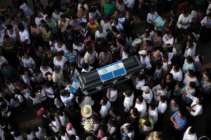 People carry the coffin of 13-year-old Juan Armando Coy Cal, who was killed by a man in his primary school classroom, on the streets of Tactic, in the Alta Verapaz region, some 189 km (117 miles) from Guatemala City, September 14, 2012. Angry villagers in Guatemala killed a man by setting fire to him after he hacked 8-year-old Evelyn Yanisa Saquij Bin and Armando Coy Cal to death with a machete in a school on September 12. The two children were buried today in a municipal cemetery. REUTERS/Jorge Dan Lopez (GUATEMALA - Tags: CRIME LAW SOCIETY) Published: Zář. 15, 2012, 4:18 dop.