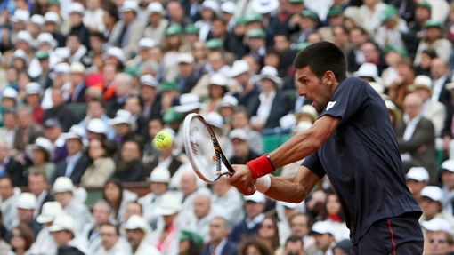 Novak Djokovič odráží míček na Rafaela Nadala během finále French Open 2012.
