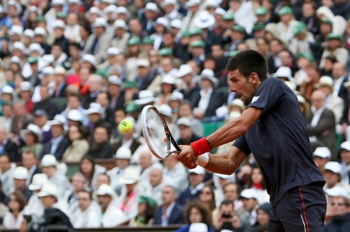 Novak Djokovič odráží míček na Rafaela Nadala během finále French Open 2012.