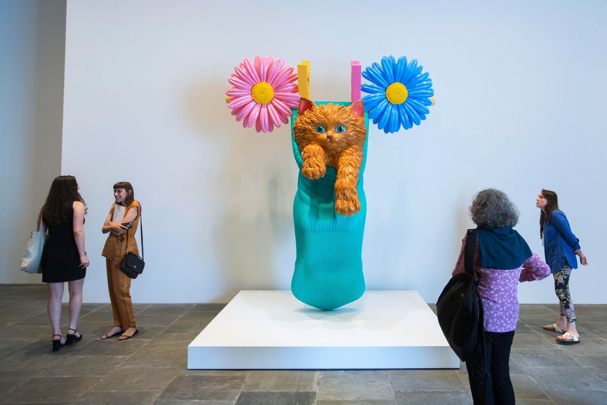 Journalists look at a sculpture before the opening of a Jeff Koons retrospective at the Whitney Museum of American Art in New York