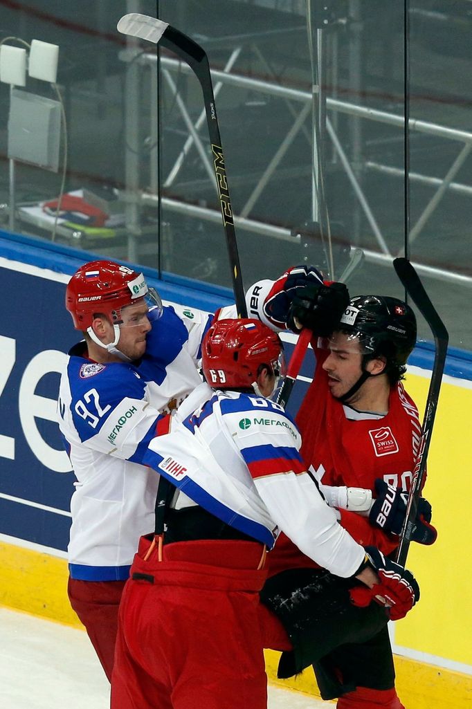 Russia's Alexander Burmistrov (C) and Yevgeni Kuznetsov (L) clash with Switzerland's Denis Hollenstein (R) during their men's ice hockey World Championship Group B game a