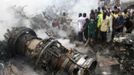 People gather near the engine of a plane, after it crashed into a neighbourhood in Ishaga disrict, an outskirt of Nigeria's commercial capital Lagos June 3, 2012. There were no survivors among the 147 people on board a domestic passenger aircraft that crashed in the Nigerian city of Lagos on Sunday, an official of the National Emergency Management Agency (NEMA), told Reuters. REUTERS/Akintunde Akinleye (NIGERIA - Tags: DISASTER TRANSPORT TPX IMAGES OF THE DAY) Published: Čer. 3, 2012, 8:19 odp.