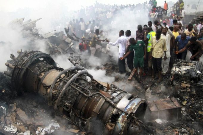 People gather near the engine of a plane, after it crashed into a neighbourhood in Ishaga disrict, an outskirt of Nigeria's commercial capital Lagos June 3, 2012. There were no survivors among the 147 people on board a domestic passenger aircraft that crashed in the Nigerian city of Lagos on Sunday, an official of the National Emergency Management Agency (NEMA), told Reuters. REUTERS/Akintunde Akinleye (NIGERIA - Tags: DISASTER TRANSPORT TPX IMAGES OF THE DAY) Published: Čer. 3, 2012, 8:19 odp.