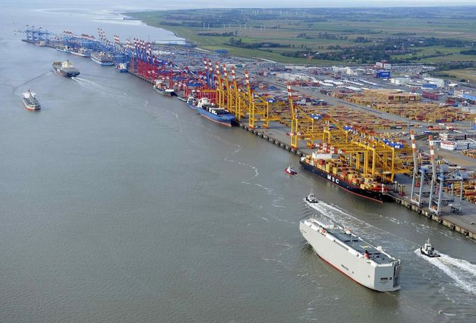 A RoRo ship transporting cars (foreground R) sails along the river Elbe towards the North Sea (background) beside a shipping terminal in the harbour of the northern German town of Bremerhaven, late October 8, 2012. Export vehicles from Europe are transported to all parts of the world through Bremerhaven, which is one of the biggest automobile ports in the world. Picture taken October 8. REUTERS/Fabian Bimmer (GERMANY - Tags: TRANSPORT BUSINESS MARITIME) Published: Říj. 9, 2012, 2:06 odp.