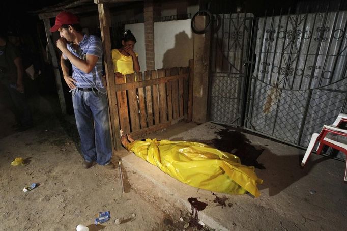 Family members react while standing next to the body of a woman who was shot dead by two gunmen on a motorcycle in San Pedro Sula March 20, 2013. San Pedro Sula, the country's second largest city after Tegucigalpa, has a homicide rate of 169 per 100,000 people and was named the world's most violent city for a second year in a row. Lax laws allow civilians to own up to five personal guns. Arms trafficking has flooded the country with nearly 70% illegal firearms. 83.4% of homicides are by firearms, compared to 60% in the United States. Picture taken March 20, 2013. REUTERS/Jorge Cabrera (HONDURAS - Tags: CRIME LAW CIVIL UNREST HEALTH) ATTENTION EDITORS: PICTURE 6 OF 39 FOR PACKAGE 'GUN CULTURE - HONDURAS' SEARCH 'HONDURAS GUN' FOR ALL IMAGES Published: Dub. 5, 2013, 11:14 dop.