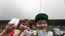 Kae Shibata (L) and Yutaro Noji show off their new Apple Inc's iPhone 5 after waiting for two days outside an Apple Store in Tokyo's Ginza district September 21, 2012. Apple Inc's iPhone 5 hit stores around the globe on Friday, with fans snapping up the device that is expected to fuel a huge holiday quarter for the consumer giant. REUTERS/Yuriko Nakao (JAPAN - Tags: BUSINESS SCIENCE TECHNOLOGY) Published: Zář. 21, 2012, 12:56 dop.