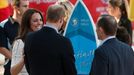 Catherine, Britain's Duchess of Cambridge, laughs with her husband Prince William after being presented with a surf board on Manly beach in Sydney