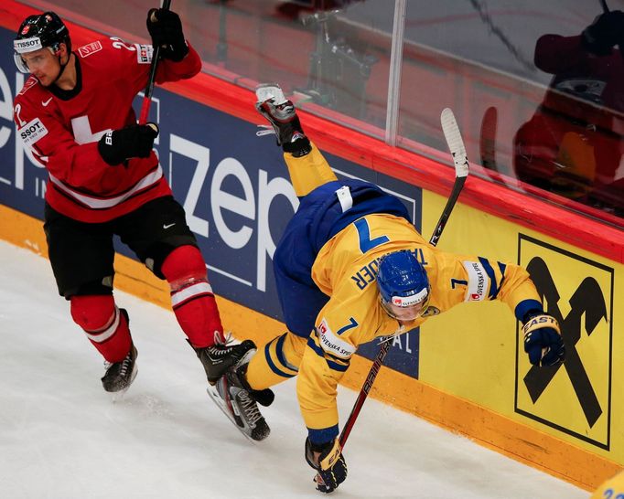 Switzerland's Nino Niederreiter fights for the puck with Sweden's Henrik Tallinder (R) during their 2013 IIHF Ice Hockey World Championship final match at the Globe Arena