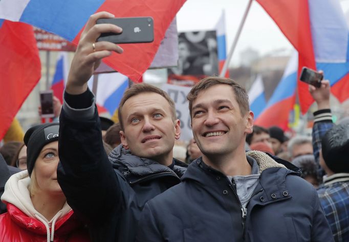 Alexej Navalnyj (uprostřed s telefonem) s manželkou Julií a bratrem Olegem na demonstraci v Moskvě v únoru 2019.