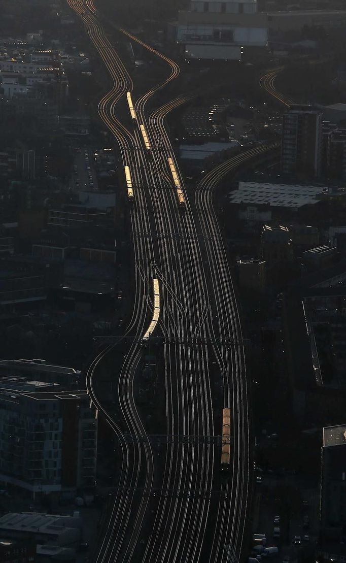 ATTENTION EDITORS - EMBARGOED FOR PUBLICATION TO 00:01 GMT JANUARY 11, 2013 Commuter trains are seen at dawn on the approach to London Bridge rail station in an aerial photograph from The View gallery at the Shard, western Europe's tallest building, in London January 8, 2013. The View, the public viewing deck accessible by high speed elevators on the 309 metre (1013 feet) Shard building, opens on February 1. Picture taken January 8, 2013. REUTERS/Stefan Wermuth (BRITAIN - Tags: TRAVEL CITYSCAPE) TEMPLATE OUT Published: Led. 10, 2013, 12:06 odp.