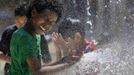 Aziz Taylor, 11 years old, of Washington DC, plays in a water fountain to beat the heat gripping the nation's capital while in the Capital Heights neighborhood of Washington, July 2, 2012. REUTERS/Larry Downing (UNITED STATES - Tags: SOCIETY TPX IMAGES OF THE DAY ENVIRONMENT) Published: Čec. 2, 2012, 7:29 odp.