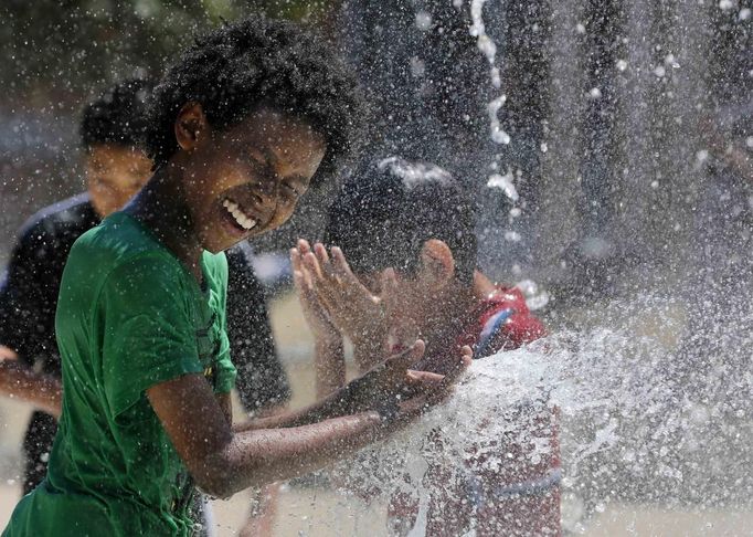 Aziz Taylor, 11 years old, of Washington DC, plays in a water fountain to beat the heat gripping the nation's capital while in the Capital Heights neighborhood of Washington, July 2, 2012. REUTERS/Larry Downing (UNITED STATES - Tags: SOCIETY TPX IMAGES OF THE DAY ENVIRONMENT) Published: Čec. 2, 2012, 7:29 odp.