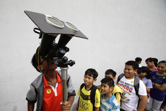 Children take turns to look at planet Venus transiting across the sun at a public viewing at the Singapore Science Centre, June 6, 2012. REUTERS/Tim Chong (SINGAPORE - Tags: ENVIRONMENT SCIENCE TECHNOLOGY) Published: Čer. 6, 2012, 5:37 dop.