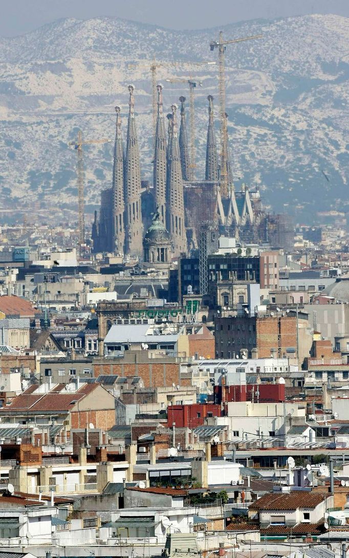 Slavná Gaudího katedrála Sagrada Familia v Barceloně po sněhové přeháňce. Sníh ještě můžete pozorovat na hoře Tibidabo, která leží na obzoru. 9. březen 2010.