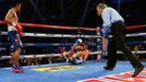 Chris Algieri (C) of the U.S. falls after taking a punch from Manny Pacquiao (L) of the Philippines during their World Boxing Organisation (WBO) 12-round welterweight tit