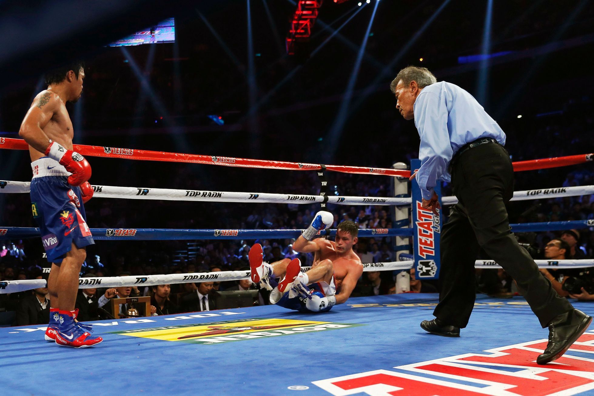 Algieri of the U.S. falls after taking a punch from Pacquiao of the Philippines during their WBO 12-round welterweight title fight in Macau