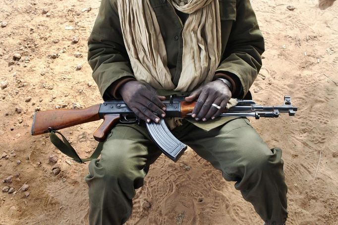 A Malian soldier holds an AK-47 in his lap at a military checkpoint in Diabaly January 26, 2013. REUTERS/Joe Penney (MALI - Tags: MILITARY CIVIL UNREST POLITICS CONFLICT) Published: Led. 26, 2013, 7:20 odp.