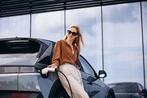 Žena nabíjí elektromobil, ilustrační foto