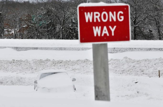 A car is seen buried in snow along the Long Island Expressway in the Suffolk County area of New York February 9, 2013. A blizzard packing hurricane-force winds pummeled the northeastern United States on Saturday, killing at least one person, leaving about 600,000 customers without power and disrupting thousands of flights. REUTERS/Shannon Stapleton (UNITED STATES - Tags: ENVIRONMENT SOCIETY DISASTER) Published: Úno. 9, 2013, 3:23 odp.