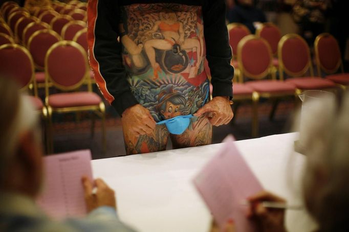 Michael Newman, 60, an Aviation Technical School teacher, from Plainfield, Indiana, shows off his Pinocchio tattoo to the judges during the National Tattoo Association Convention in Cincinnati, Ohio April 14, 2012. Newman started late in life getting tattoos but has made up for lost time, having between 600-700 hours performed on him, costing around $50,000. Winning about 60 awards, mostly in the 'Unique' category, over the past 7 years, he claims his Pinocchio tattoo is always a "crowd favourite." Picture taken April 14, 2012. REUTERS/Jason Reed (UNITED STATES - Tags: SOCIETY) ATTENTION EDITORS PICTURE 24 OF 31 FOR PACKAGE 'ADDICTED TO THE NEEDLE' TO FIND ALL PICTURES SEARCH 'ADDICTED NEEDLE' TEMPLATE OUT Published: Čer. 29, 2012, 1 odp.