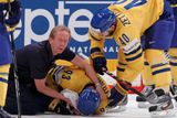 Henrik Zetterberg a lékař švédského týmu se sklánějí nad zraněným Johanem Franzénem