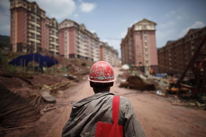 A labourer walks at a construction site where houses will be raised for people who will be relocated in Badong, on the banks of the Yangtze River, 100km (62 miles) from the Three Gorges dam in Hubei province in this August 7, 2012 file photo. China relocated 1.3 million people during the 17 years it took to complete the Three Gorges dam. Even after finishing the $59 billion project last month, the threat of landslides along the dam's banks will force tens of thousands to move again. It's a reminder of the social and environmental challenges that have dogged the world's largest hydroelectric project. While there has been little protest among residents who will be relocated a second time, the environmental fallout over other big investments in China has become a hot-button issue ahead of a leadership transition this year. Picture taken on August 7, 2012. To match story CHINA-THREEGORGES/ REUTERS/Carlos Barria/Files (CHINA - Tags: POLITICS ENVIRONMENT BUSINESS ENERGY EMPLOYMENT) Published: Srp. 22, 2012, 8:28 odp.