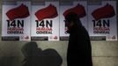 A man walks past posters calling for a general strike in Madrid November 13, 2012. Spain's two largest labour unions has called a general strike on November 14, the second against the conservative government since they took power in December and coinciding with industrial action in Portugal on the same day. REUTERS/Sergio Perez (SPAIN - Tags: BUSINESS EMPLOYMENT POLITICS CIVIL UNREST) Published: Lis. 13, 2012, 10:53 dop.