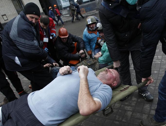 Anti-government protesters carry an injured man on a stretcher to medical staff after clashes with riot police in Independence Square in Kiev February 20, 2014. Ukrainian