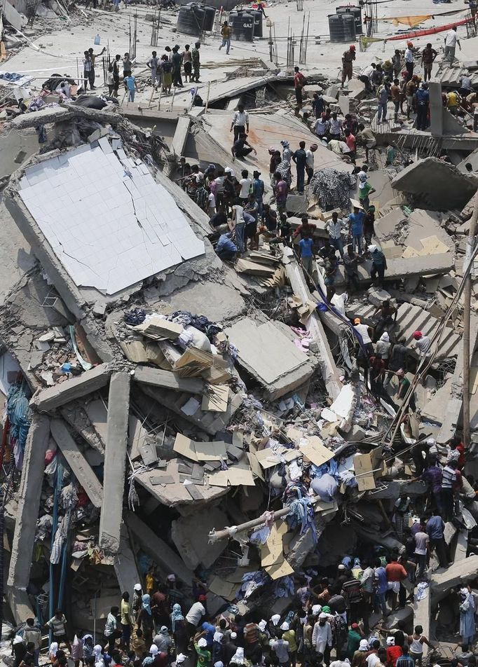 People rescue garment workers trapped under rubble at the Rana Plaza building after it collapsed, in Savar, 30 km (19 miles) outside Dhaka April 24, 2013. An eight-storey block housing garment factories and a shopping centre collapsed on the outskirts of the Bangladeshi capital on Wednesday, killing at least 25 people and injuring more than 500, the Ntv television news channel reported. REUTERS/Andrew Biraj (BANGLADESH - Tags: DISASTER BUSINESS) T Published: Dub. 24, 2013, 6:02 odp.