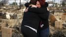 Neighbors Lucille Dwyer (R) and Linda Strong embrace after looking through the wreckage of their homes devastated by fire and the effects of Hurricane Sandy in the Breezy Point section of the Queens borough of New York October 31, 2012. The U.S. Northeast began crawling back to normal on Wednesday after monster storm Sandy crippled transportation, knocked out power for millions and killed at least 45 people in nine states with a massive storm surge and rain that caused epic flooding. REUTERS/Shannon Stapleton (UNITED STATES - Tags: ENVIRONMENT DISASTER) Published: Říj. 31, 2012, 3:48 odp.