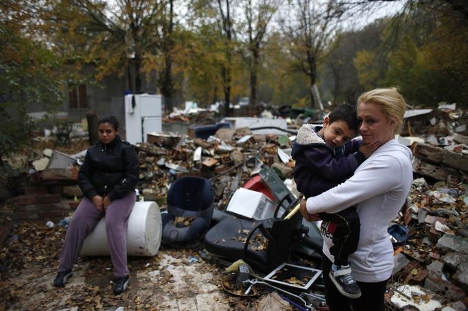 Teresa Echevarria holds her son Ezequiel next to her daughter Maria as they wait for a bulldozer to demolish two homes at the Spanish gypsy settlement of Puerta de Hierro, in the outskirts of Madrid November 20, 2012. Fifty-four families have been living in Puerta de Hierro, on the banks of the Manzanares river for over 50 years. Since the summer of 2010, the community has been subject to evictions on the grounds that the dwellings are illegal. Families, whose homes have been demolished, move in with relatives whose houses still remain while the debris keeps piling up around them as more demolitions take place. REUTERS/Susana Vera (SPAIN - Tags: CIVIL UNREST BUSINESS CONSTRUCTION) Published: Lis. 20, 2012, 4:43 odp.