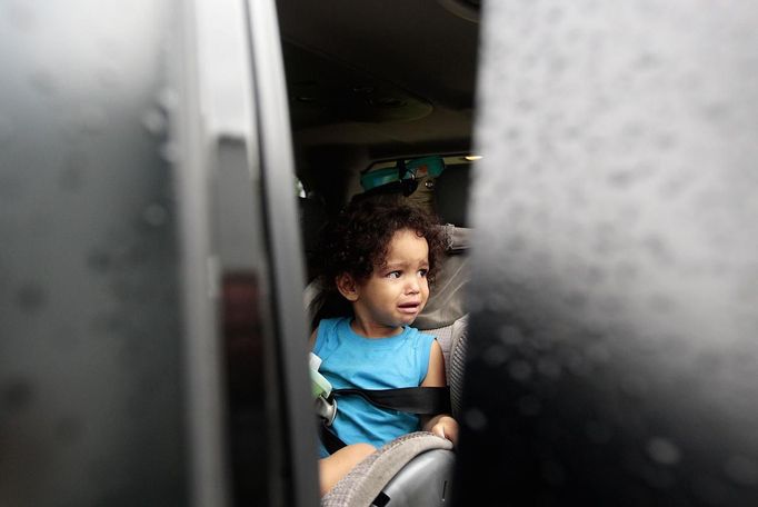 Jaden Fabian, 1, cries in her car seat as her family evacuates their home as Tropical Storm Isaac heads towards the Louisiana coast line in Oakville, Louisiana, August 28, 2012. Tropical Storm Isaac was near hurricane force as it bore down on the U.S. Gulf Coast on Tuesday and was expected to make landfall in the New Orleans area seven years after it was devastated by Hurricane Katrina. REUTERS/Sean Gardner (UNITED STATES - Tags: ENVIRONMENT DISASTER TRANSPORT) Published: Srp. 28, 2012, 1:46 odp.