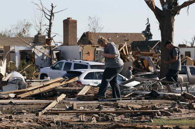 A couple tries to find valuables in their tornado-destroyed home in Moore, Oklahoma May 21, 2013. Rescuers went building to building in search of victims and thousands of survivors were homeless on Tuesday after a massive tornado tore through the Oklahoma City suburb of Moore, wiping out whole blocks of homes and killing at least 24 people. REUTERS/Rick Wilking (UNITED STATES - Tags: DISASTER ENVIRONMENT) Published: Kvě. 22, 2013, 1:59 dop.