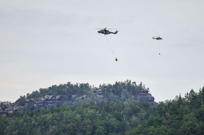 Vrtulník Sikorsky UH-60 Black Hawk polské policie (vlevo) během hašení požáru v Národním parku České Švýcarsko. 27. 7. 2022