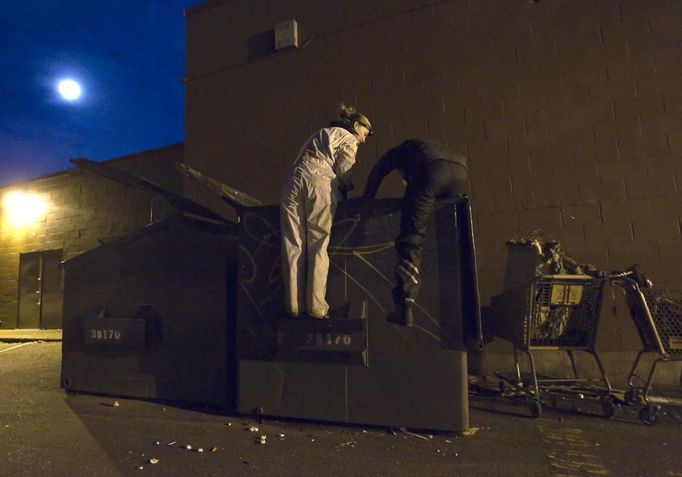 Anna-Rae Douglass, 23 (L) and Robin Pickell, who are both 'freegans', climb into a dumpster behind an organic grocery store in Coquitlam, British Columbia April 5, 2012. A 'freegan' is someone who gathers edible food from the garbage bins of grocery stores or food stands that would otherwise have been thrown away. Freegans aim to spend little or no money purchasing food and other goods, not through financial need but to try to address issues of over-consumption and excess. Picture taken April 5, 2012. REUTERS/Ben Nelms (CANADA - Tags: SOCIETY TPX IMAGES OF THE DAY) ATTENTION EDITORS PICTURE 15 OF 21 FOR PACKAGE 'DUMPSTER DIVING FOR FOOD' Published: Kvě. 15, 2012, poledne