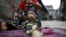 Drumpal Choudhary, 11, a street performer ties his legs with a wooden pole as he gets ready to perform a trick at a street in Kathmandu August 15, 2012. Drumpal, his brother, Gchan and sister, Shivani, came to Kathmandu from India 5 years ago. They earn their living by performing tricks on the streets of Kathmandu. According to Drumpal, they earn around $10 a day by performing tricks, which is not enough to feed their 10-member family living together in a small hut without a proper toilet or any basic needs. REUTERS/Navesh Chitrakar (NEPAL - Tags: SOCIETY POVERTY IMMIGRATION) Published: Srp. 15, 2012, 4:47 odp.