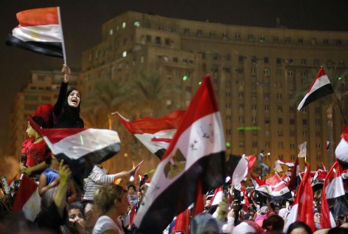 Protesters, who are against Egyptian President Mohamed Mursi, react in Tahrir Square in Cairo July 3, 2013. Egypt's armed forces overthrew elected Islamist President Mohamed Mursi on Wednesday and announced a political transition with the support of a wide range of political, religious and youth leaders. A statement published in Mursi's name on his official Facebook page after Egypt's armed forces General Abdel Fattah al-Sisi's speech said the measures announced amounted to "a full military coup" and were "totally rejected". REUTERS/Suhaib Salem (EGYPT - Tags: POLITICS CIVIL UNREST) Published: Čec. 3, 2013, 8:07 odp.